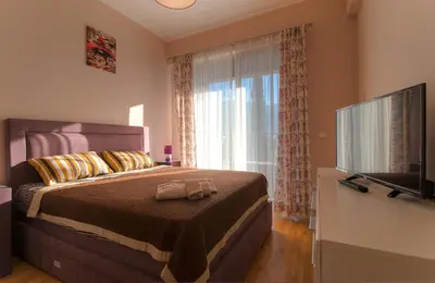 a bedroom with a bed with a large window at Harmonia Sunrise Apartments in Budva