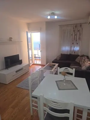 a living room with a white table and a couch at City kvart Delta apartment in Podgorica