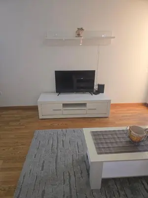 a living room with a tv on a white entertainment center at City kvart Delta apartment in Podgorica