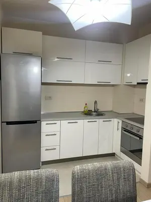 a kitchen with white cabinets and a stainless steel refrigerator at City kvart apartman 35 eur in Podgorica