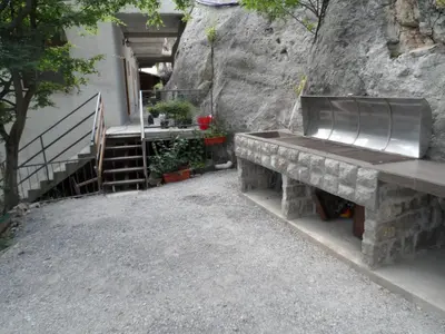 a bench sitting next to a building with a staircase at Pataki Guesthouse in Petrovac na Moru