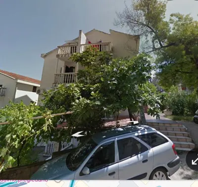 a white car parked in front of a building at Apartman Budva in Budva