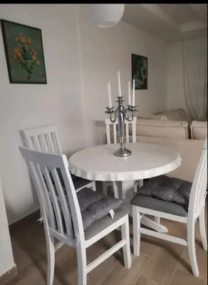 a white dining room table with two chairs and a table with candles at Apartman Budva in Budva