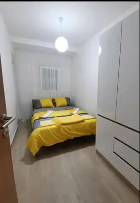 a bedroom with a bed with a yellow comforter at Apartman Budva in Budva