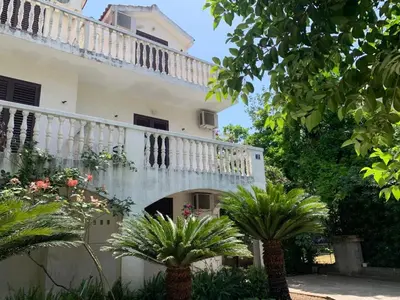 a building with a balcony and some plants at House Irena in Budva