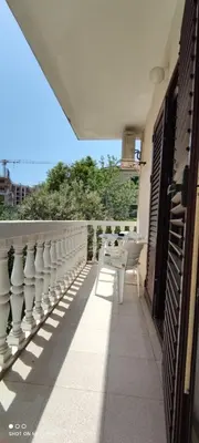 a balcony with tables and chairs on a building at House Irena in Budva