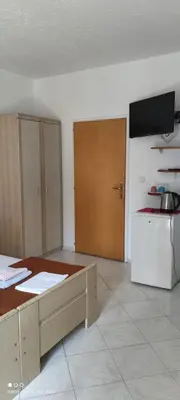 a room with a kitchen with a counter and a refrigerator at House Irena in Budva