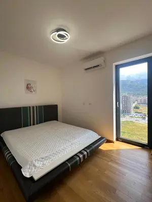 a bed in a room with a large window at Luxury Apartment SOHO CITY in Bar