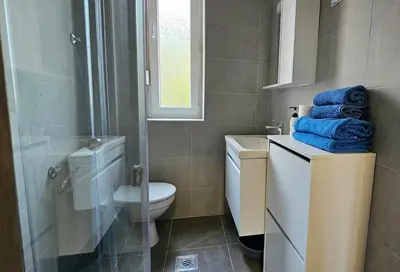 a bathroom with a toilet and a shower with blue towels at Zero Distance Studio in Podgorica