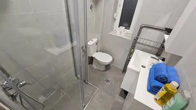 a bathroom with a shower with a toilet and a sink at Zero Distance Studio in Podgorica