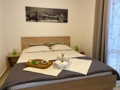 a bed with a tray of towels and a bridge at Junto al mar in Ulcinj