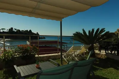 a patio with chairs and a bench and the ocean at Junto al mar in Ulcinj