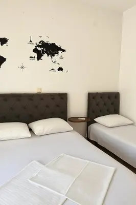 a room with two beds and a map of the world on the wall at Junto al mar in Ulcinj