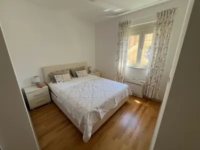 a white bedroom with a bed and a window at Hidden Gem, Budva in Budva