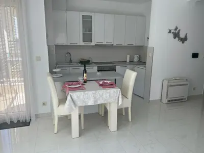 a white kitchen with a table and chairs and a table at Hidden Gem, Budva in Budva