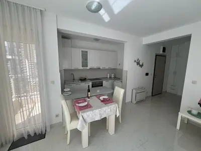 a kitchen with a table and chairs and a table and a table at Hidden Gem, Budva in Budva