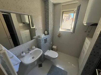 a white bathroom with a sink and a toilet at Hidden Gem, Budva in Budva