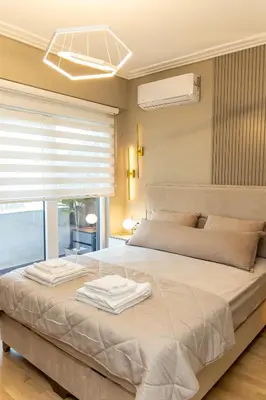 a bedroom with a large bed with two towels on it at Kaltak Luxury Stay in Bar