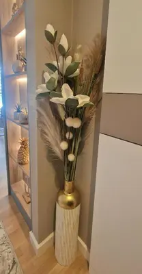 a vase filled with white flowers in a room at Kaltak Luxury Stay in Bar