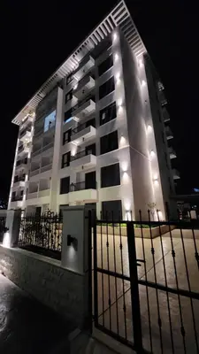 a large white building with lights on it at night at LIMONCELLO Apartment in Bar