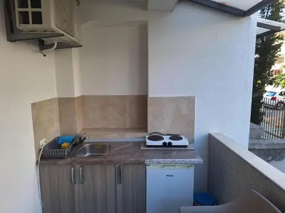 a small kitchen with a sink and a counter top at Apartmani Miladinović in Sutomore