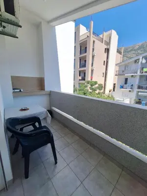 a room with a table and a chair and a window at Apartmani Miladinović in Sutomore