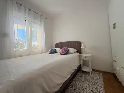 a bedroom with a large white bed with two pillows at Apartman Sunce in Podgorica