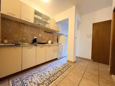 a large kitchen with white cabinets and a sink at Apartman Sunce in Podgorica