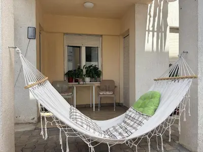 a hammock on the porch of a house at Apartman Sunce in Podgorica