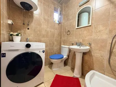 a bathroom with a washer and a toilet and a sink at Apartman Sunce in Podgorica