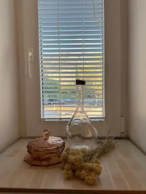 a glass bottle sitting on the floor next to a window at Stari Bar Apartments in Stari Bar