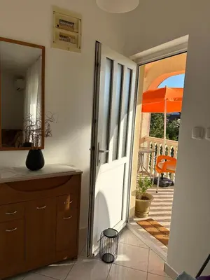 an open door to a patio with an orange umbrella at Stari Bar Apartments in Stari Bar