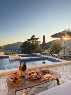 a table with food and drinks next to a swimming pool at Villa Lotos in Budva