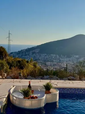 a pool with a table with a bottle of wine at Villa Lotos in Budva