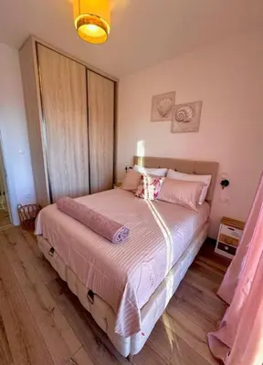 a bedroom with a bed with pink pillows at Villa Lotos in Budva