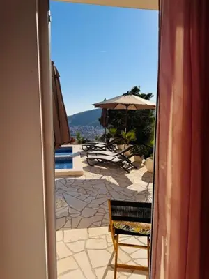 a view of a patio with an umbrella and a chair at Villa Lotos in Budva