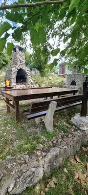 a picnic table with a stone oven in a park at Livari CAMPING in Livari