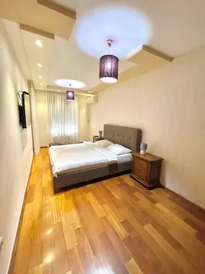 a bedroom with a bed and a wooden floor at Podgorica Apartment Center in Podgorica