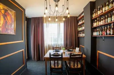 a dining room with a table and chairs and a chandelier at Podgorica Boulevard Residence in Podgorica