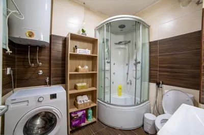 a bathroom with a shower and a washing machine at Podgorica Boulevard Residence in Podgorica