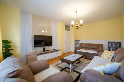 a living room with two couches and a flat screen tv at Podgorica Boulevard Residence in Podgorica
