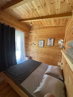 a bed in a log cabin with a window at Ada in Ulcinj