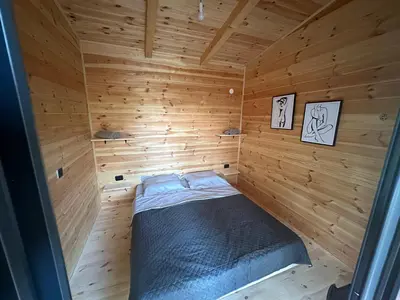 a small room with a bed in a wooden cabin at Ada in Ulcinj