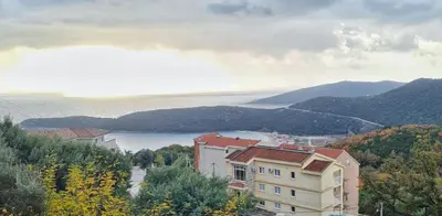 a building on a hill with a view of a lake at Apartment Dragicevic 9 - with garage in Budva