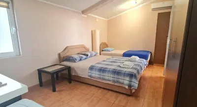 a small bedroom with two beds and a table at Apartment Dragicevic 9 - with garage in Budva