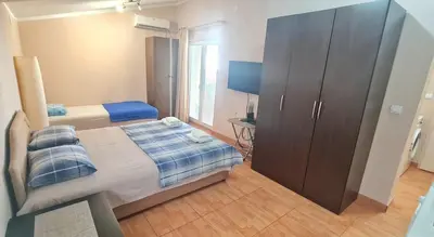 a bedroom with a bed and a large cabinet at Apartment Dragicevic 9 - with garage in Budva