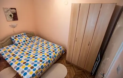 a small bedroom with a bed and a cabinet at Budva Apartment in Budva