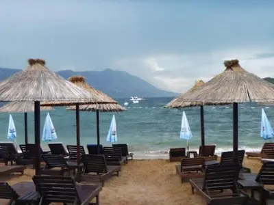 a group of chairs and umbrellas on a beach at Budva Apartment in Budva