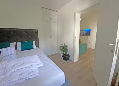 a bedroom with a large white bed with blue pillows at Little Heaven Escape in Budva