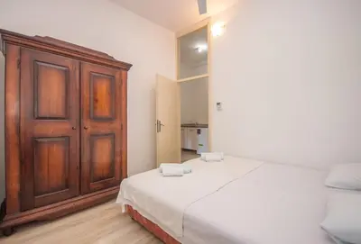 a bedroom with a large bed and a wooden cabinet at Central & quiet location inside Old town Kotor in Kotor